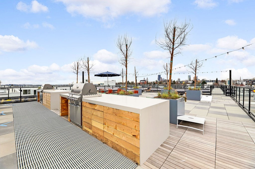a rooftop deck with a bar and a view of the city