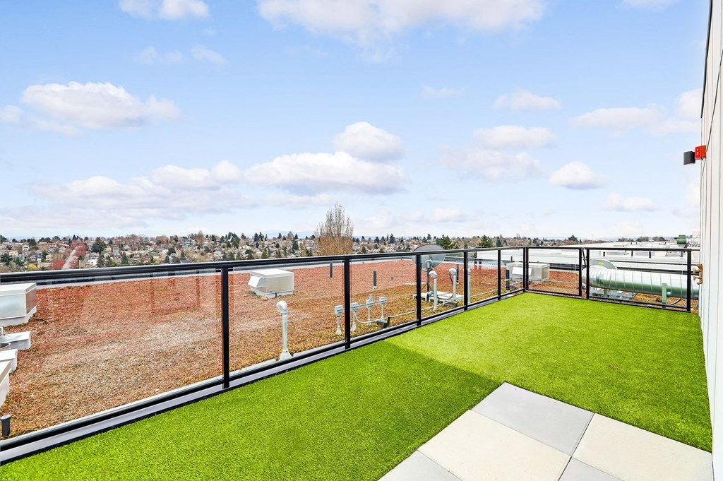 a balcony with grass and a view of the city
