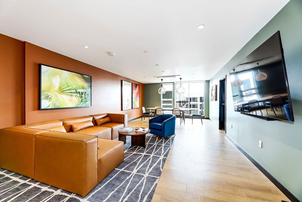 a living room with leather furniture and a large tv