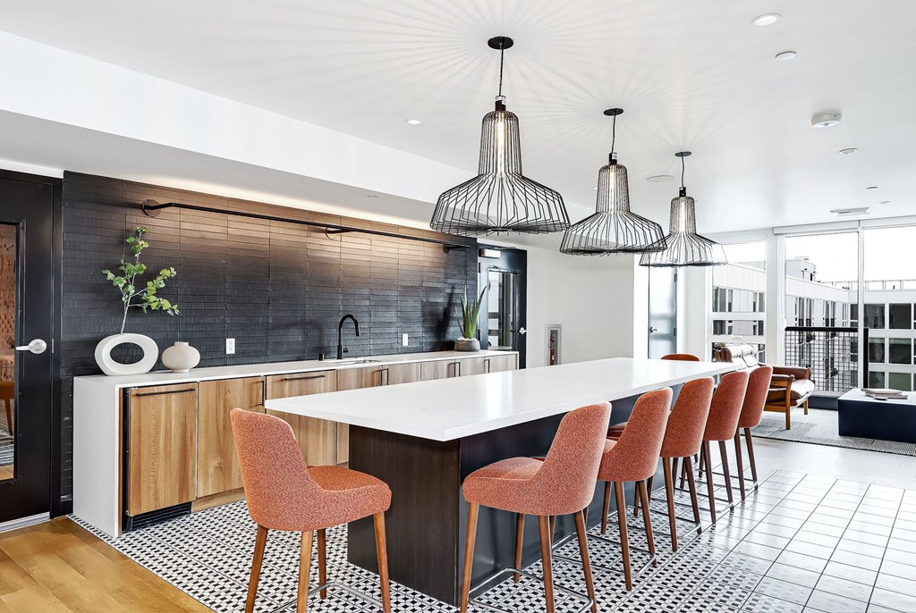 a kitchen with a long island and chairs in front of a table