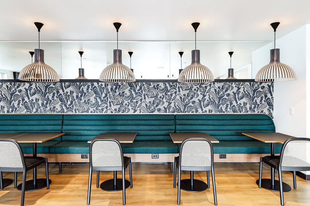 a restaurant with tables and chairs in front of a green couch