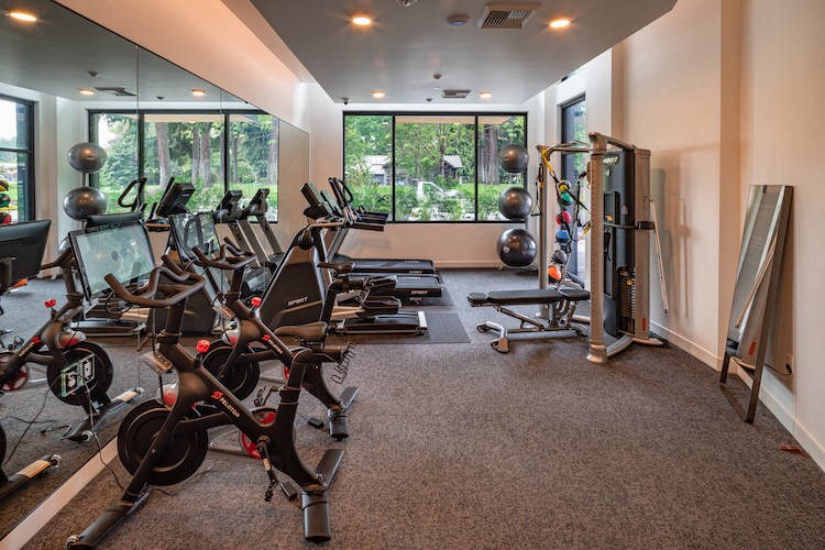 the gym has plenty of exercise equipment and a large window