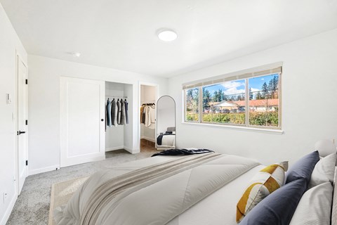 a bedroom with a bed and a large window
