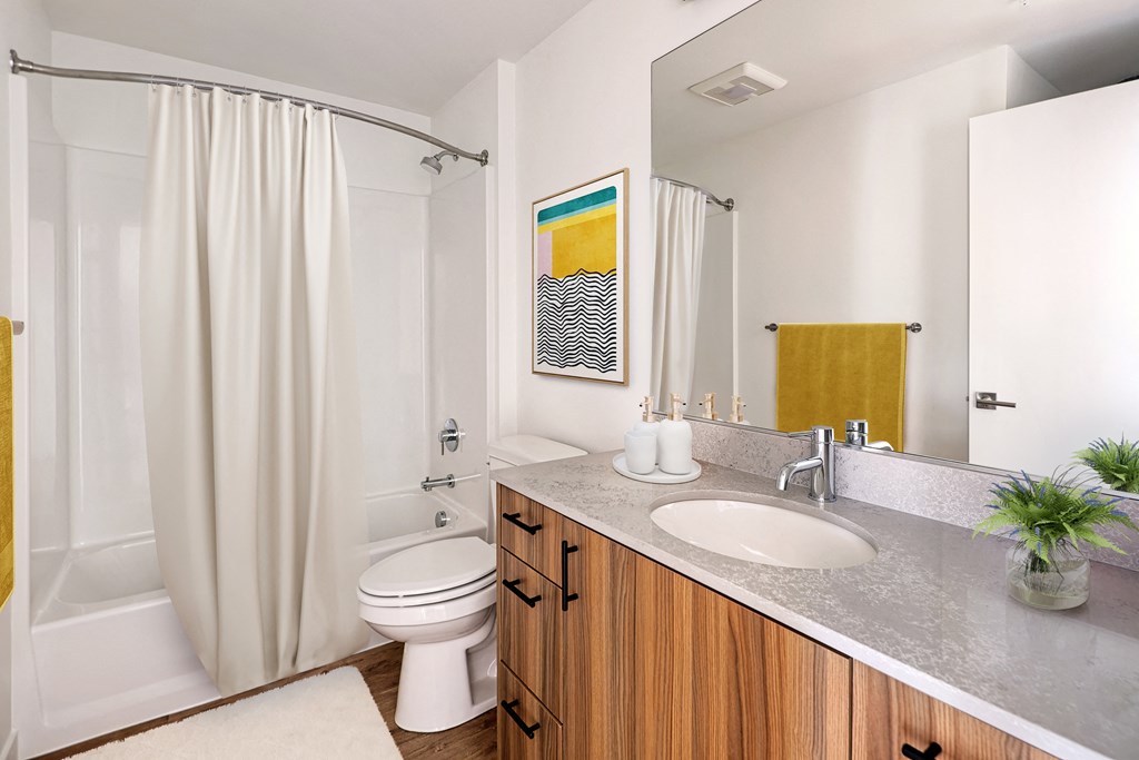 a bathroom with a white shower and toilet and a sink