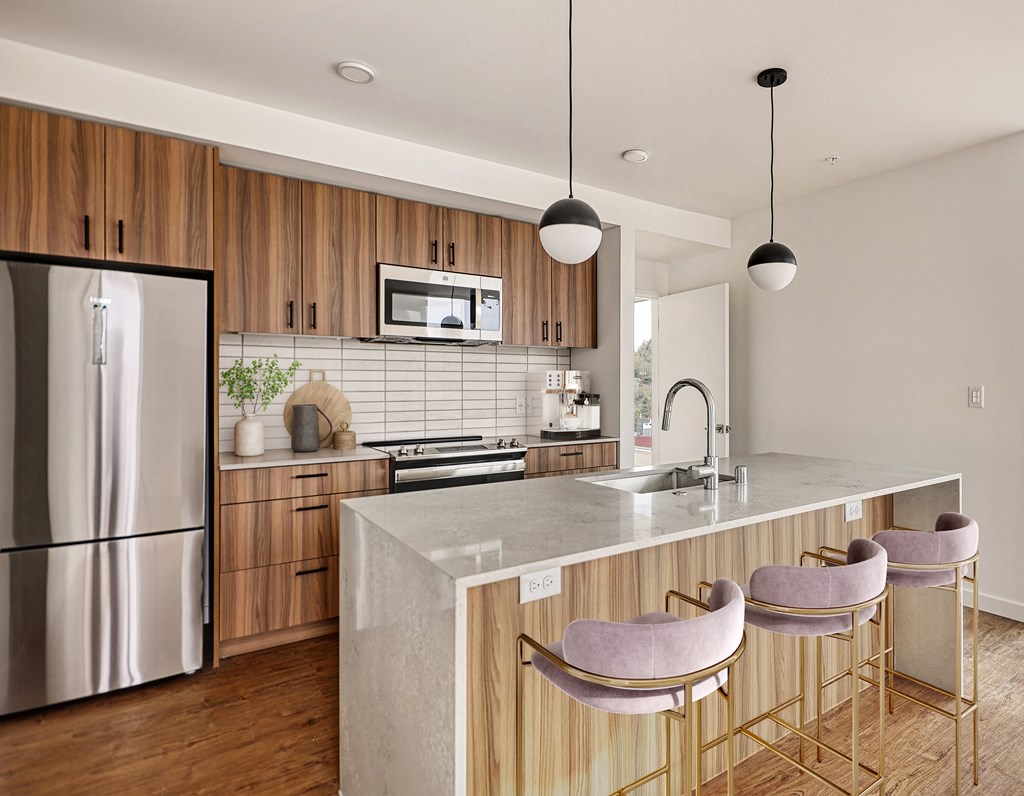 a kitchen with a large island and a stainless steel refrigerator