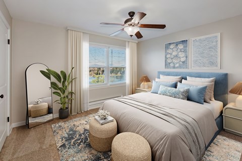 A bedroom with a large bed and a ceiling fan.