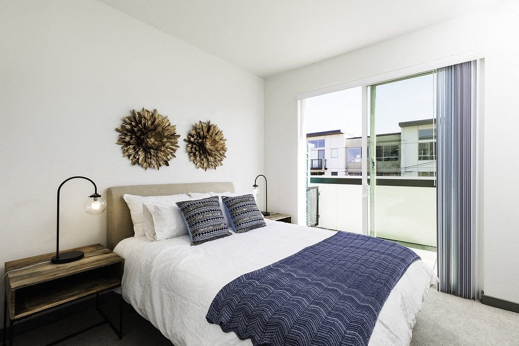 a bedroom with a bed and a large window