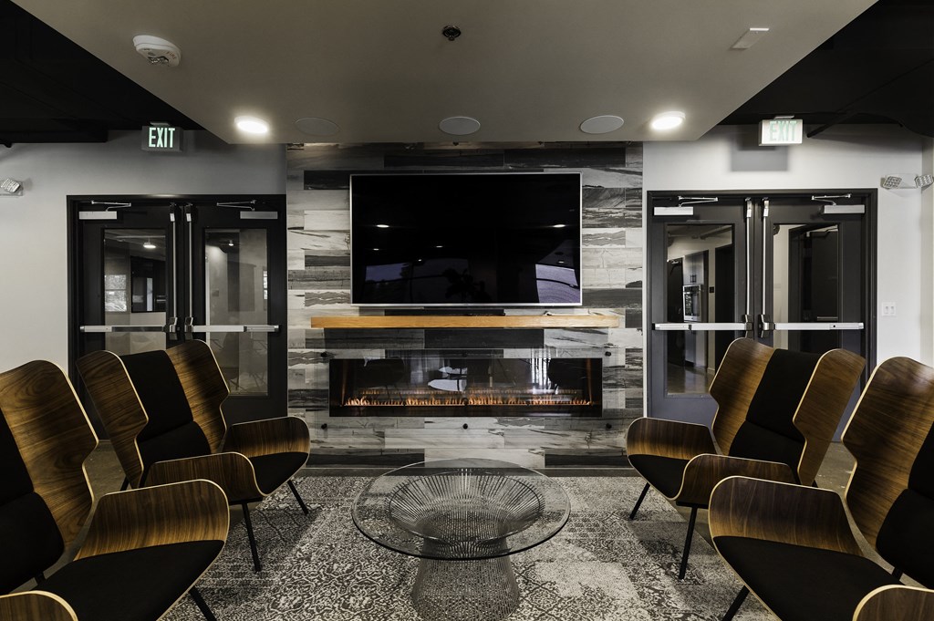 a meeting room with chairs and a television in front of a fireplace