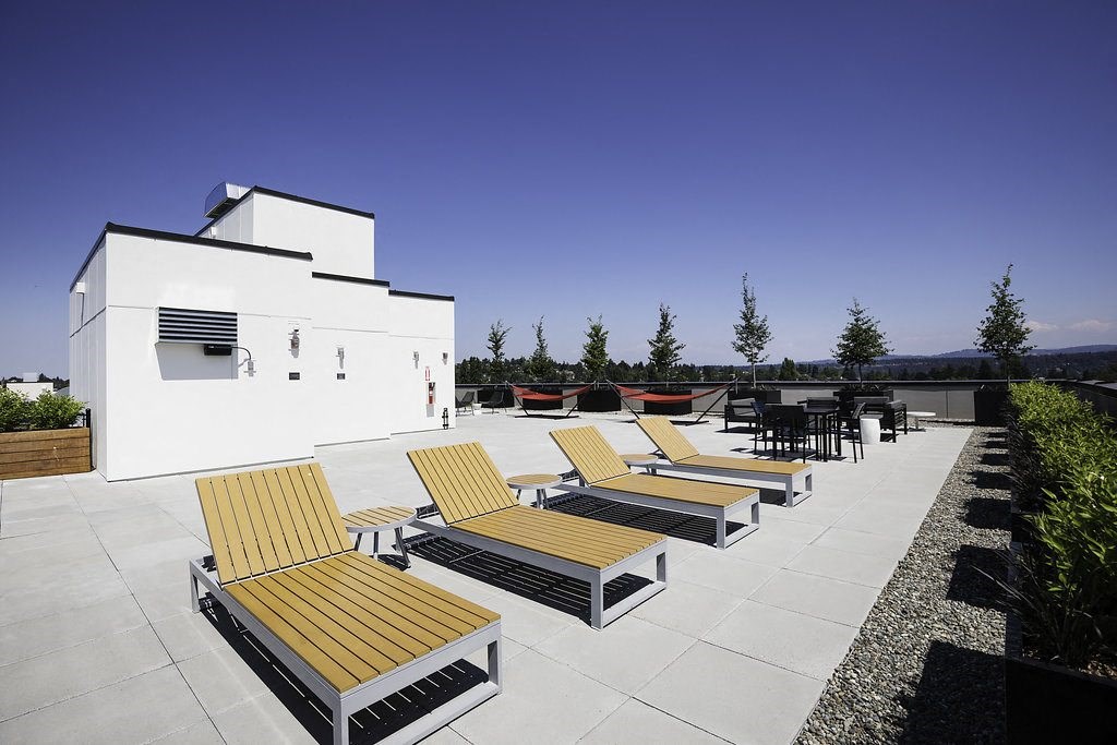 a row of wooden lounge chairs on a roof terrace