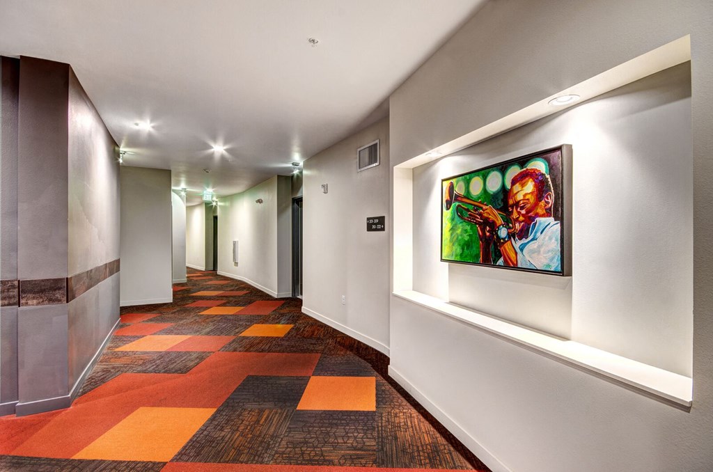 a painting on a wall at the end of a long hallway