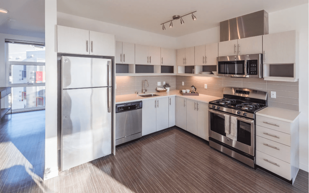 a kitchen with white cabinetry and stainless steel appliances