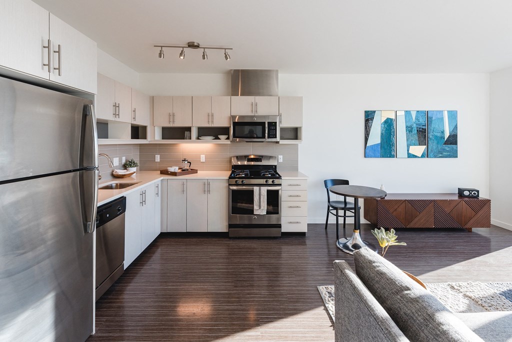 a kitchen with white cabinets and stainless steel appliances