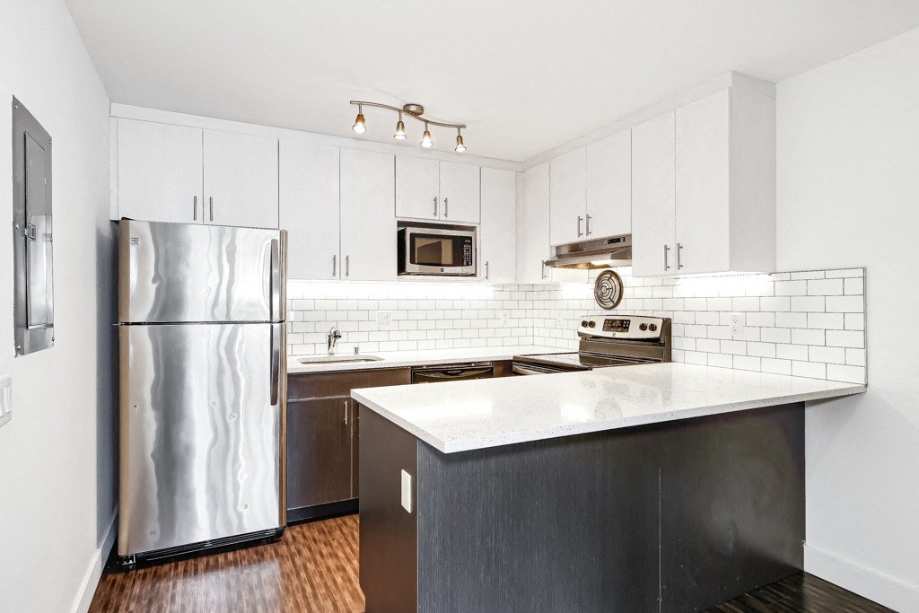 a kitchen with stainless steel appliances and white cabinets