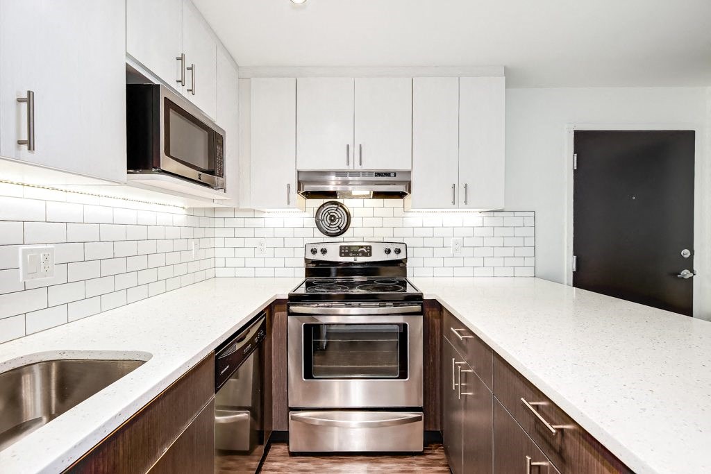 a modern kitchen with white cabinets and stainless steel appliances