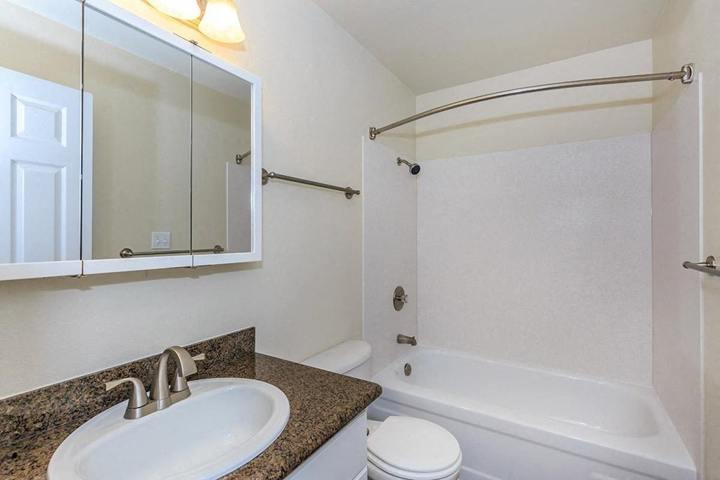 a bathroom with a sink and a tub and a mirror