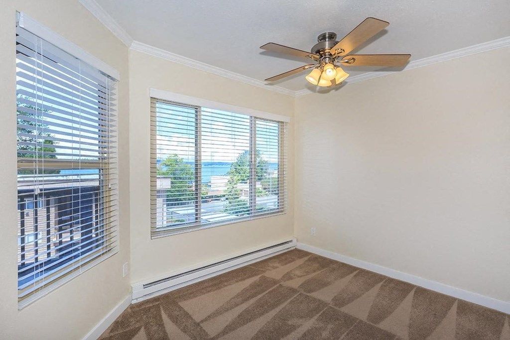 a living room with a large window and a ceiling fan