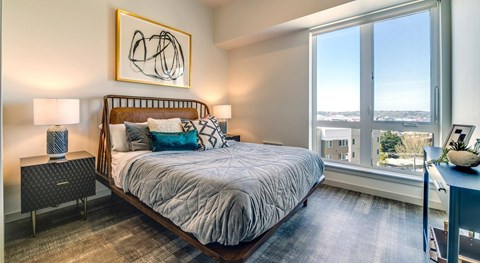 A bedroom with a large bed and a painting on the wall.