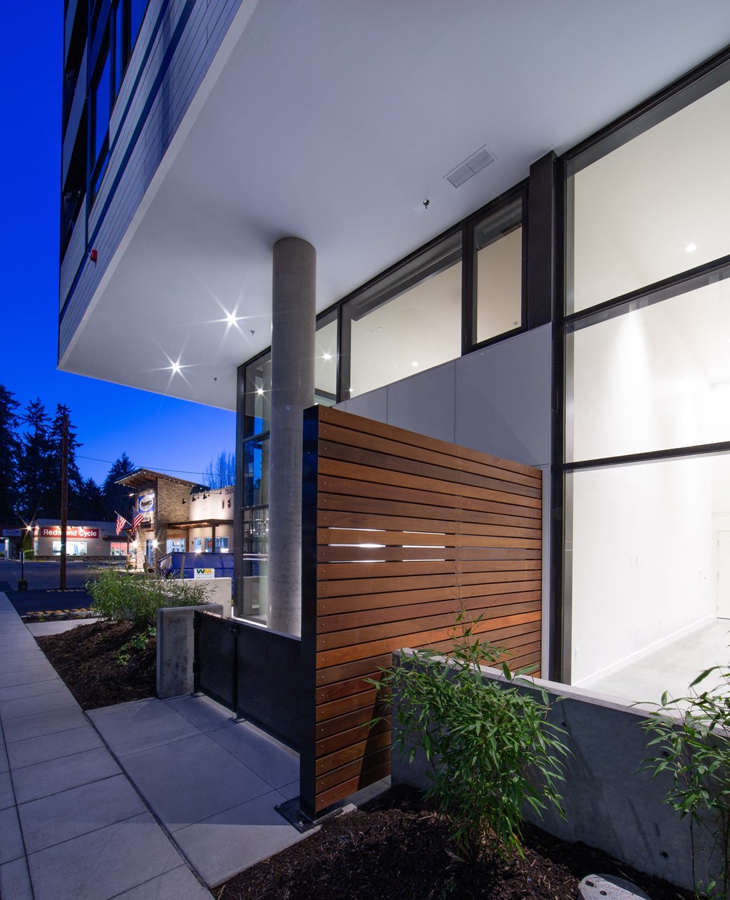 a wall of windows with a wooden door on the side of a building