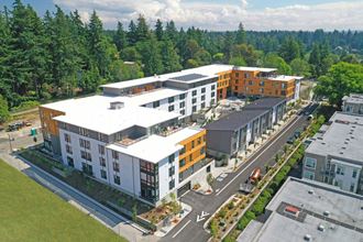 an aerial view of an apartment complex with trees in the background