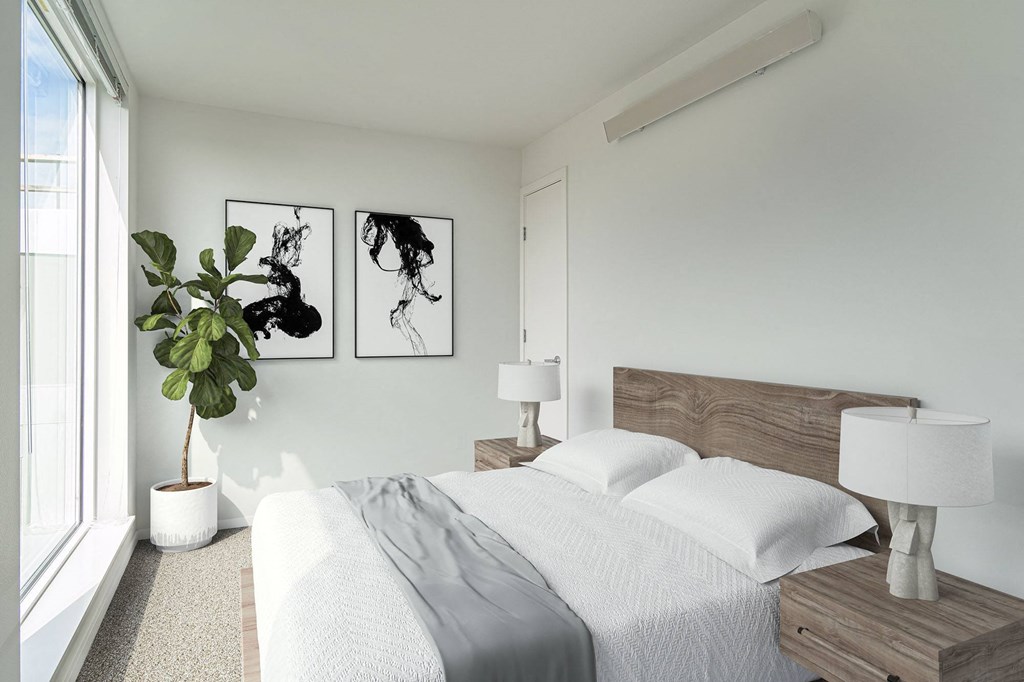 a bedroom with white walls and a white bed with a wooden headboard