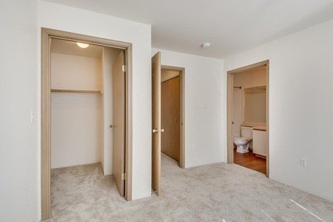 a bedroom and a hallway with doors to a bathroom and a toilet