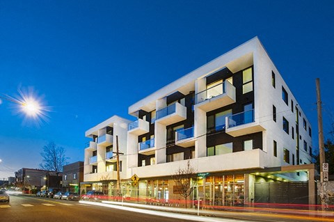 a rendering of a modern apartment building on a city street