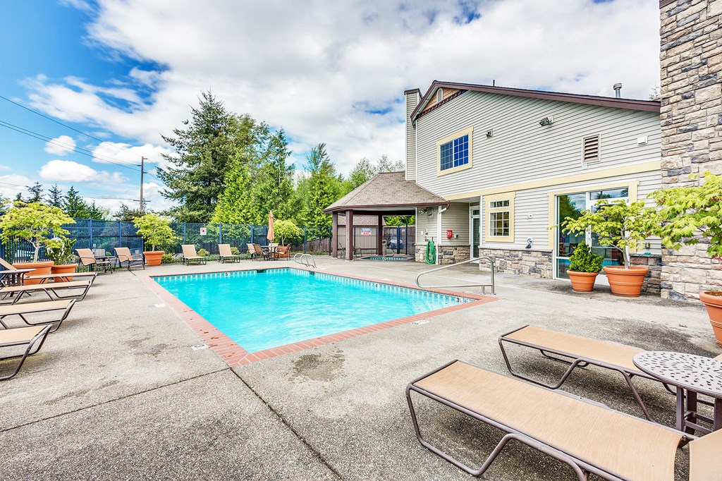 the pool is next to a house with a resort style pool