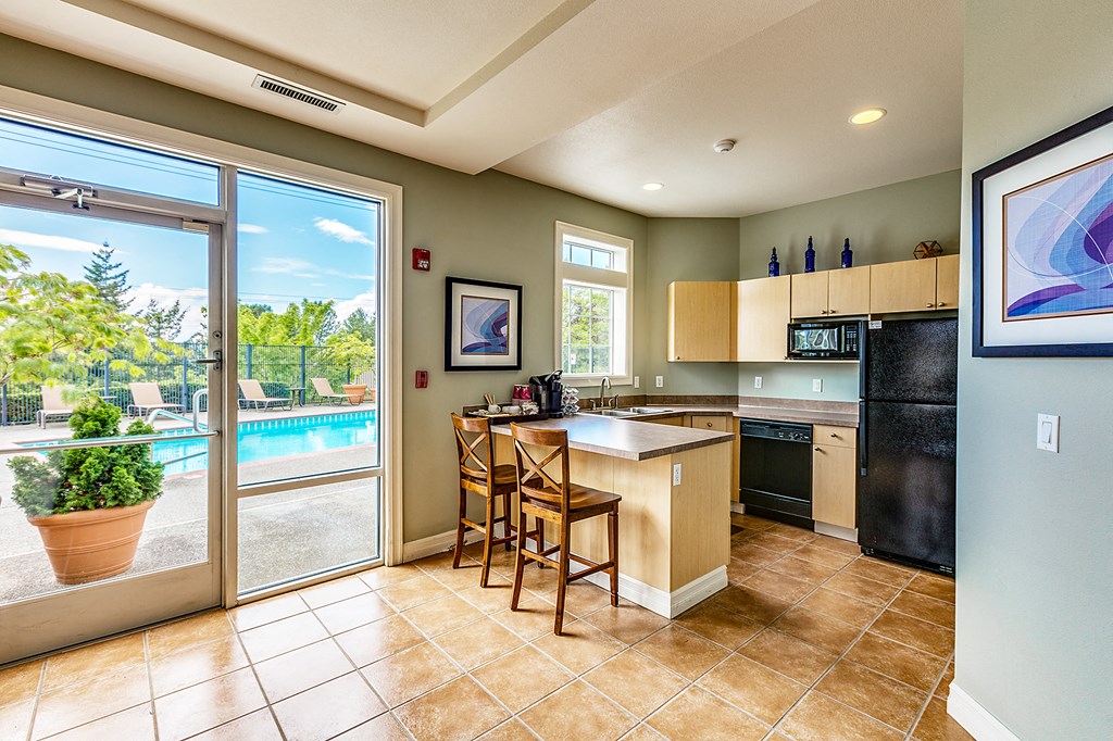a kitchen with a bar and a sliding glass door to a pool