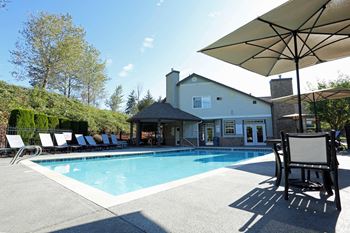 swimming pool with sundeck and lounge chairs at Copper Creek apartments in Milton WA