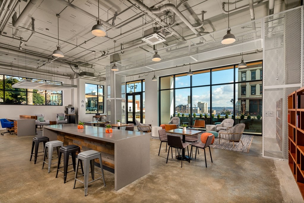 a communal area with tables and chairs and large windows