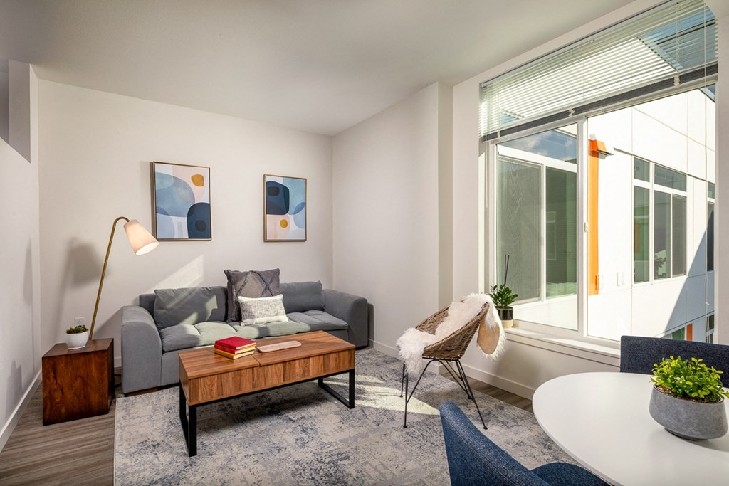 a living room with a couch and a coffee table and a large window