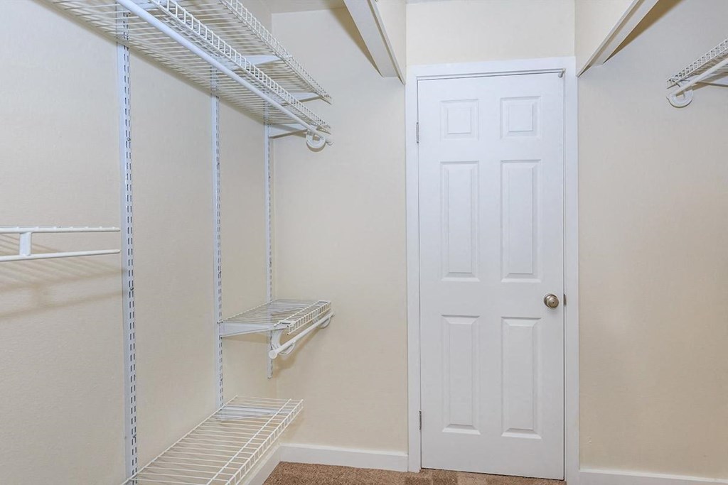 a closet with a white door and a white closet door
