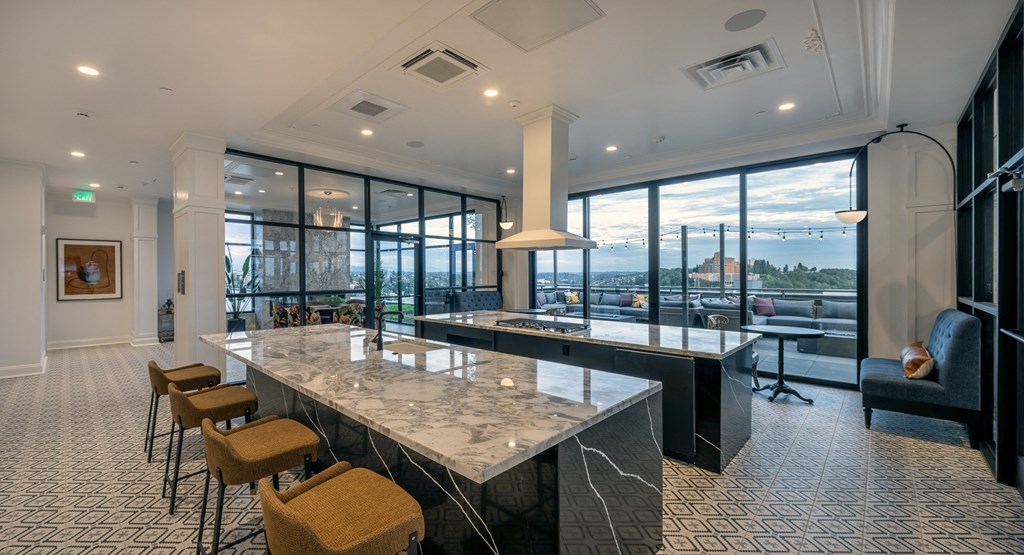 a large kitchen with marble counter tops and a view of the city