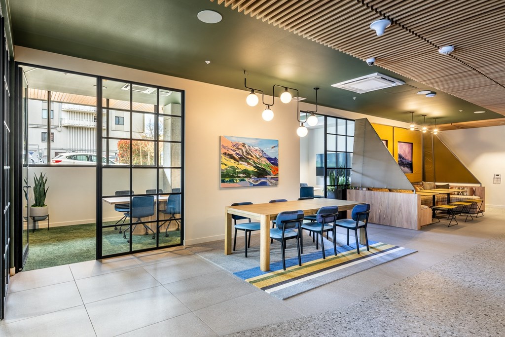 A modern office space with a large table and chairs.