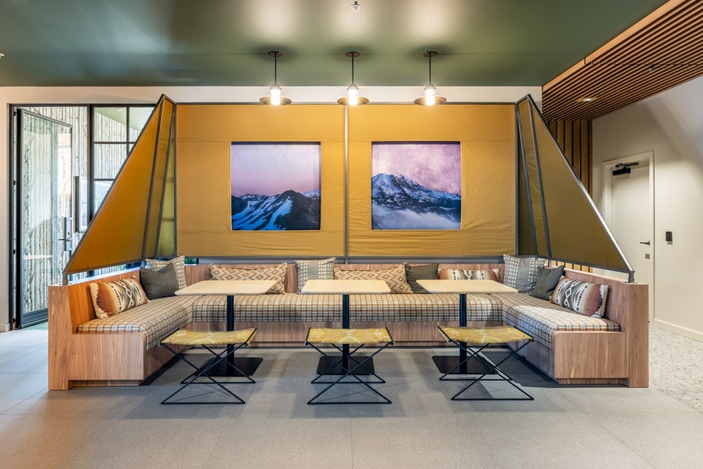 A room with a large couch and two pictures on the wall.