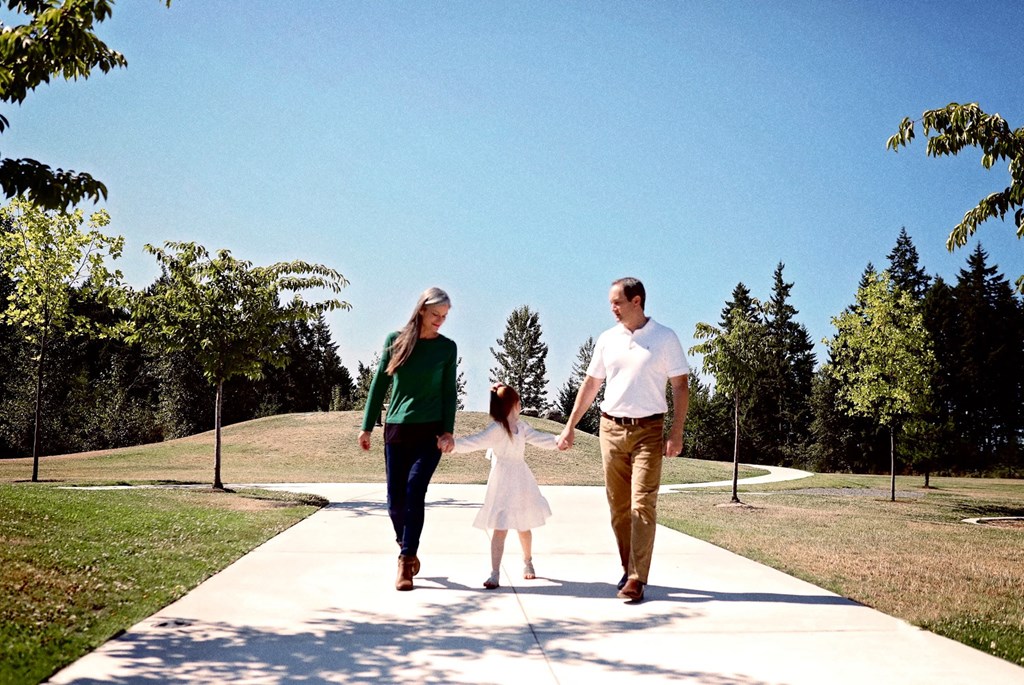 a family walking down a sidewalk holding hands