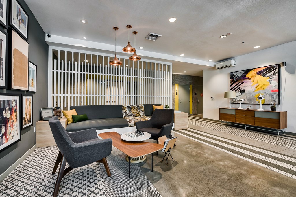 A modern living room with a grey sofa, a wooden coffee table, and a striped rug.