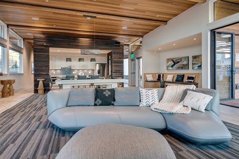 A modern living room with a grey sofa and a wooden ceiling.