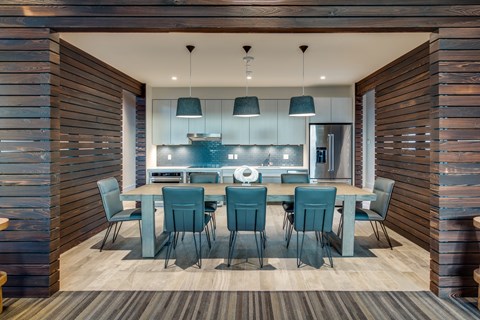 A modern kitchen with a dining table set for six.