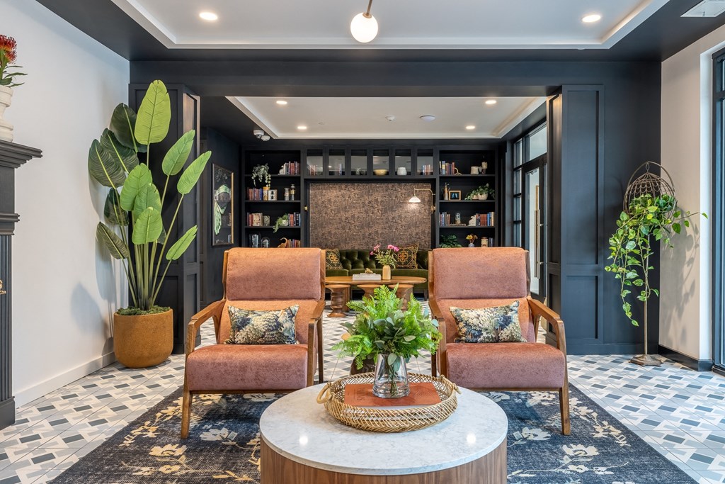 a lobby with two chairs and a table with a plant