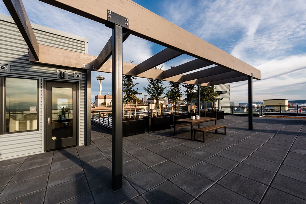 a pergola on a roof terrace with a view of the city