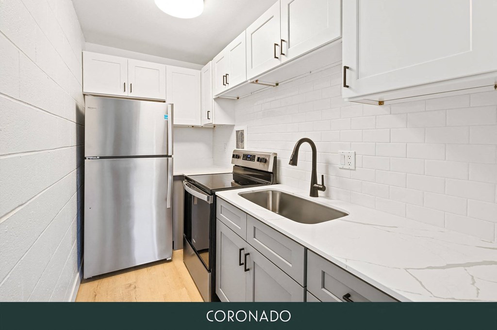 a kitchen with white cabinets and a sink and a refrigerator