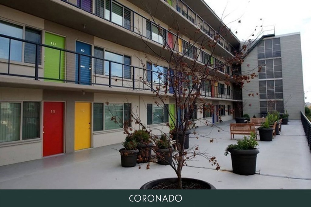 a courtyard of an apartment building with colorful doors and windows