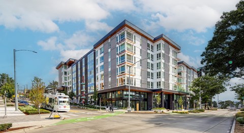 A modern multi-story building with a street in front of it.