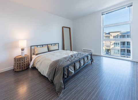 a bedroom with a bed and a large window