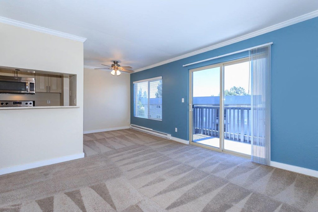 a living room with a sliding glass door to a balcony