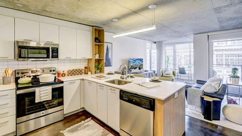 A modern kitchen with stainless steel appliances and white cabinetry.