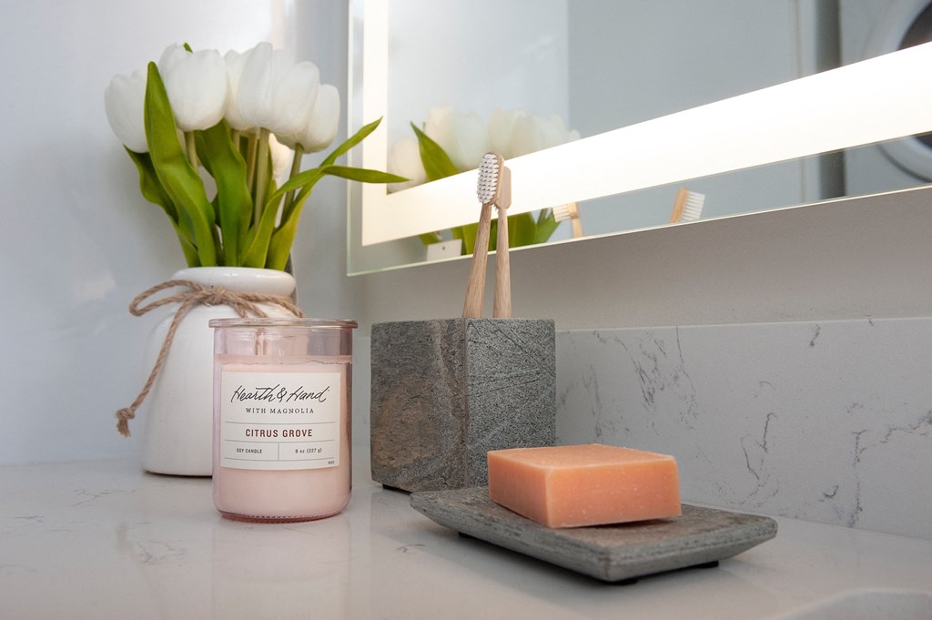 a bar of soap and a vase of flowers on a bathroom counter