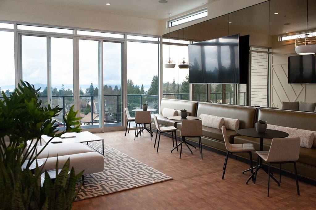 A modern living room with a large window overlooking a forest.