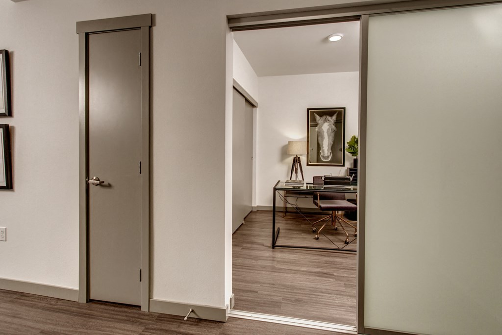 a view of a living room from a hallway with a door to a office